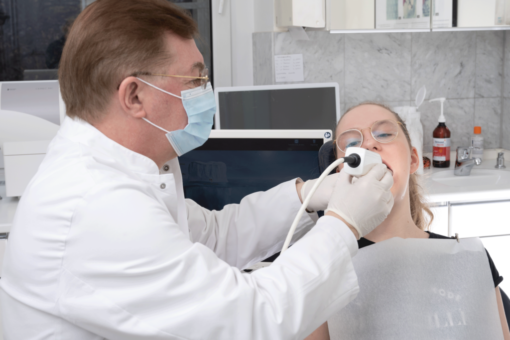 Zahnarzt Dr. Dr. Bieniek bei der Behandlung einer Patientin